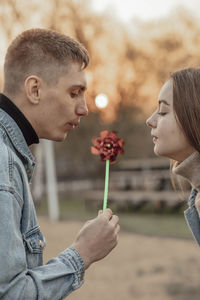 Young man and woman blowing on a wind toy, ecology concept