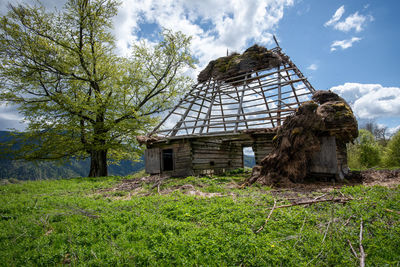 Abandoned house on field against sky