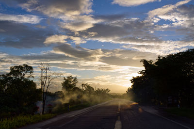 Empty road against sky at sunset