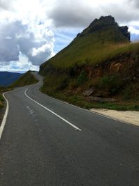 Road by mountain against sky