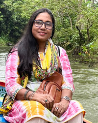 Portrait of young woman sitting on boat in lake