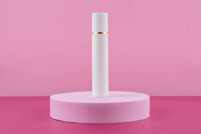 White pump cosmetic product on podium pedestal. facial cream bottle on pink background