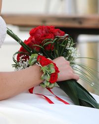 Midsection of woman holding rose bouquet