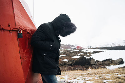 Side view of man standing on land against sky