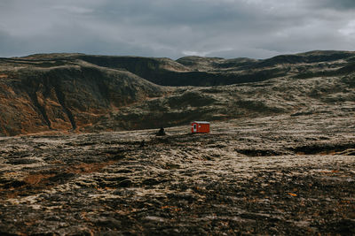 Scenic view of land and mountains against sky
