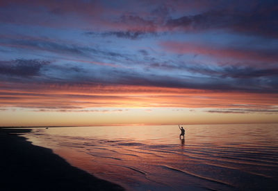 Scenic view of sea against dramatic sky during sunset