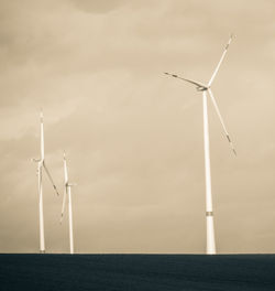 Wind turbines against sky