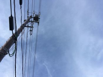 Low angle view of telephone pole against sky