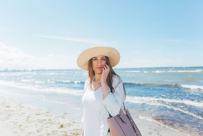 Woman standing on beach against sky