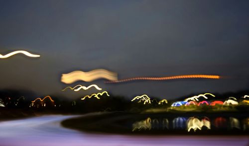 Illuminated water against sky at night