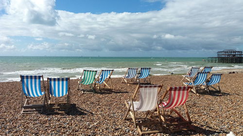 Chairs on beach against sky