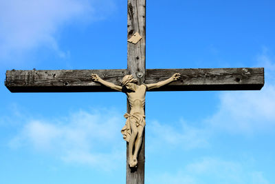 Low angle view of cross sign against blue sky