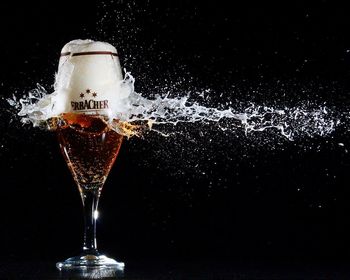 Close-up of wine glass against black background