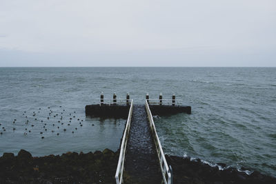 Scenic view of sea against clear sky with a pier