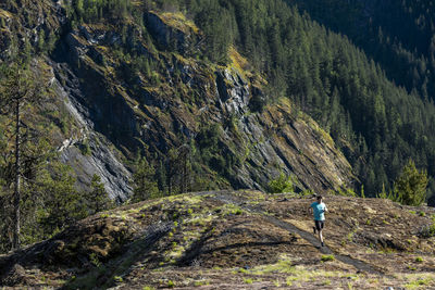 Man trail runs on a scenic alpine mountain trail in british columbia.