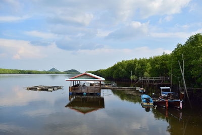 Boat moored in lake against sky