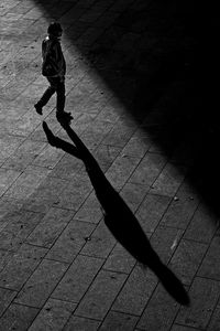 Shadow of woman walking on street