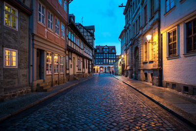 Empty street amidst buildings at night