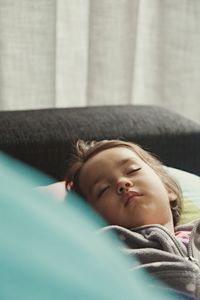 High angle view of girl sleeping on bed