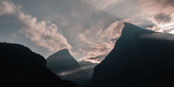 Low angle view of silhouette mountains against sky