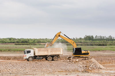 Tractor at construction site against sky