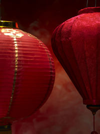 Close-up of illuminated lanterns hanging against wall