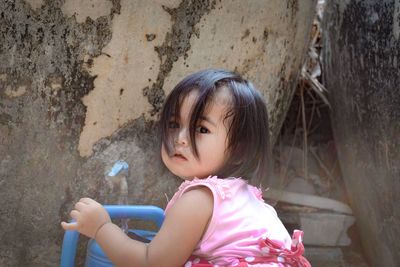 Portrait of cute baby girl against wall