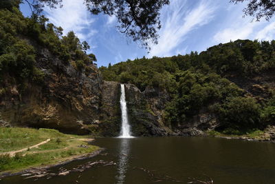 Scenic view of waterfall against sky