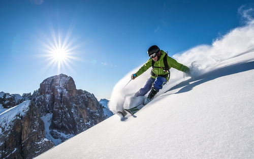 Person skiing on snowcapped mountain against sky