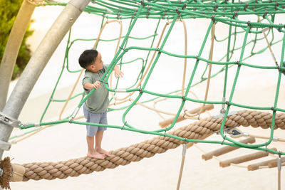 Full length of boy standing on rope