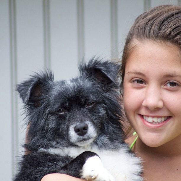 person, headshot, indoors, lifestyles, leisure activity, portrait, childhood, looking at camera, cute, elementary age, pets, togetherness, smiling, innocence, close-up, bonding, domestic animals, girls