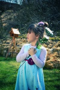 Cute girl holding flowers in yard