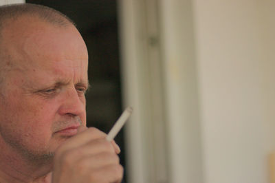 Man looking away while smoking cigarette