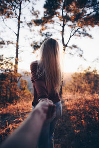 Rear view of woman standing in forest