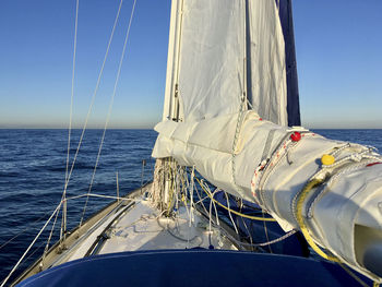 Sailboat sailing in sea against clear sky