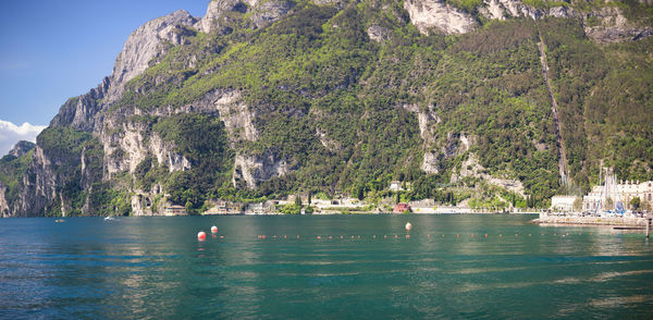 Scenic view of garda lake by mountain on sunny day