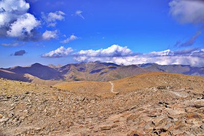 Scenic view of landscape and mountains against blue sky