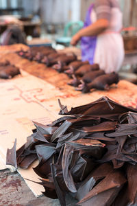 Midsection of woman selling bats on food stall at street market