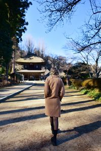 Rear view of woman walking on road