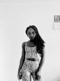 Portrait of woman standing against wall