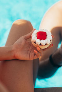 A young attractive girl holds a beautiful cake by the pool.