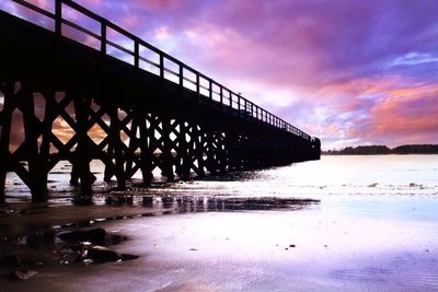 Bridge over river against cloudy sky