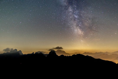 Silhouette mountains against sky at night