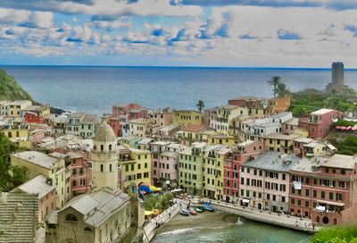 Buildings by sea against sky