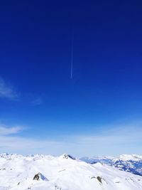 Snow covered mountain against blue sky