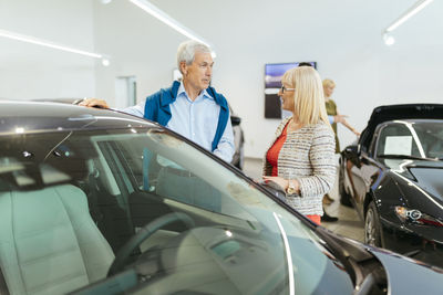 Couple looking at car in dealeship