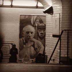 Close-up of man sitting on stone wall
