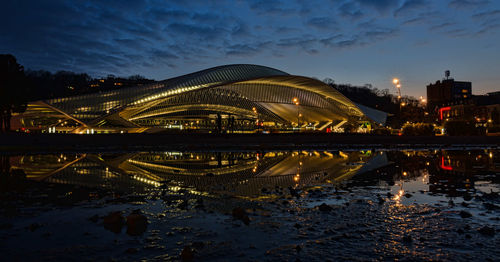 Illuminated bridge over river at night