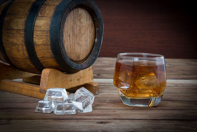 Close-up of ice cubes and whiskey in glass on table