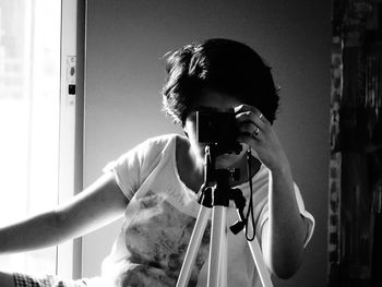 Woman photographing through camera at home